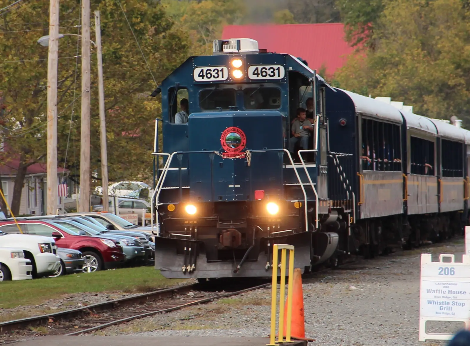 A train on the tracks running close beside dense forest