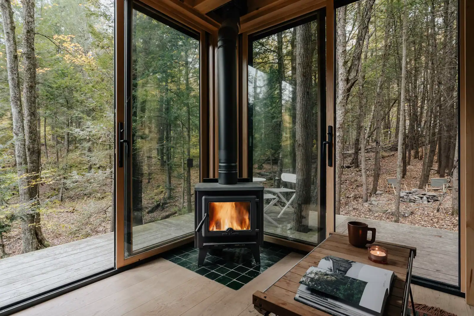 A wood-burning stove alight in the corner of a simple timber-lined room